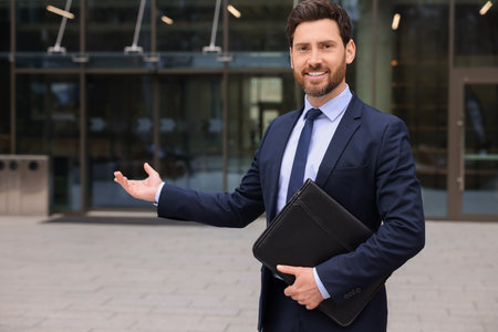 Male real estate agent with leather portfolio outdoorsの写真素材