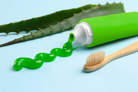 Tube of toothpaste, toothbrush and fresh aloe on light blue background, closeupの写真素材