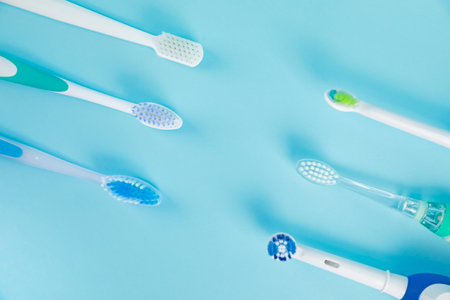 Electric toothbrushes on light blue background, flat layの写真素材
