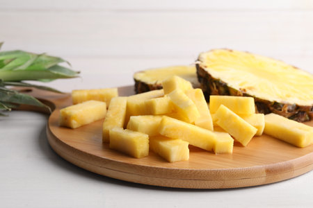Pieces of tasty ripe pineapple on white wooden table, closeupの写真素材