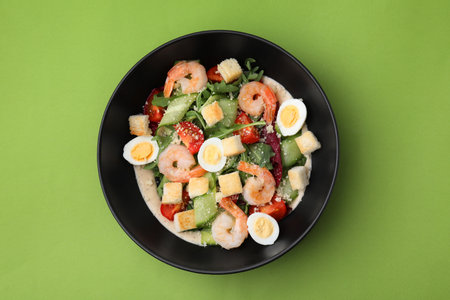 Delicious Caesar salad with shrimps on light green background, top viewの写真素材
