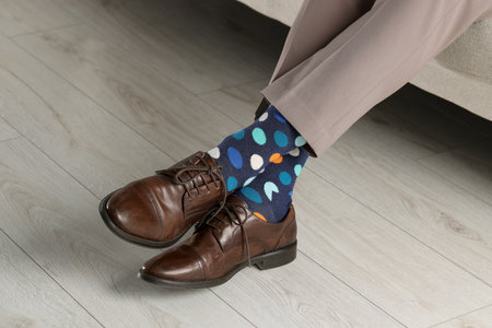 Man wearing stylish shoes and colorful socks indoors, closeup