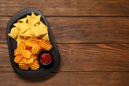 Tasty tortilla and ridged chips with ketchup on white wooden table, top view. Space for textの写真素材