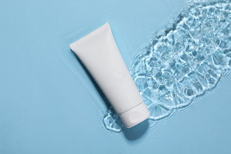 Tube of face cleansing product in against water light blue background, top viewの写真素材