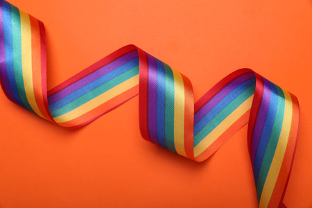 Rainbow ribbon on orange background, top view. LGBT prideの写真素材