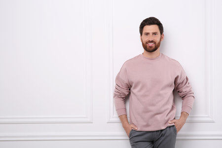 Portrait of handsome man near white wall, space for textの写真素材