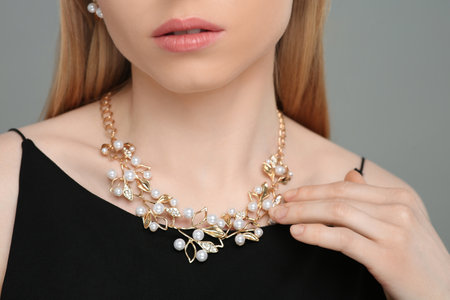 Woman with elegant necklace on gray background, closeupの写真素材