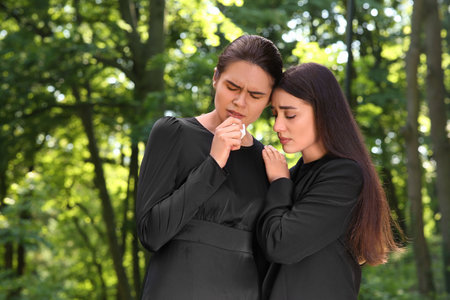 Sad women in black clothes mourning outdoors. Funeral ceremonyの写真素材