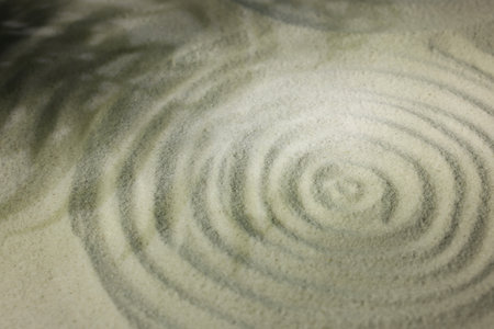 Beautiful spiral and shadows of leaves on sand, closeup. Zen gardenの写真素材
