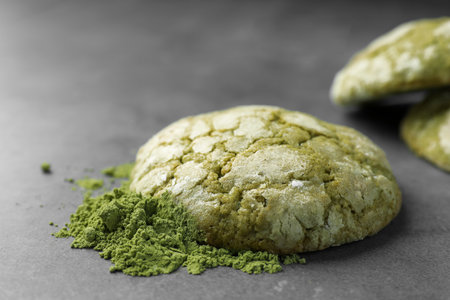 Tasty matcha cookies and powder on gray table, closeup