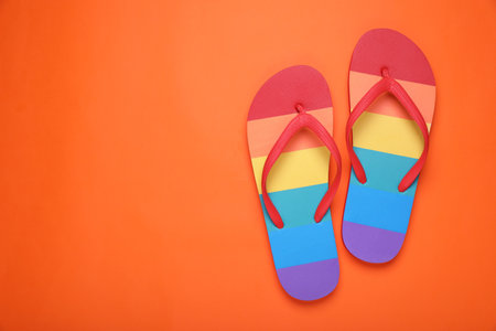 Rainbow flip flops on orange background, flat lay with space for text. LGBT prideの写真素材