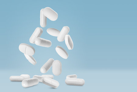 Many different pills falling on light blue background, space for text