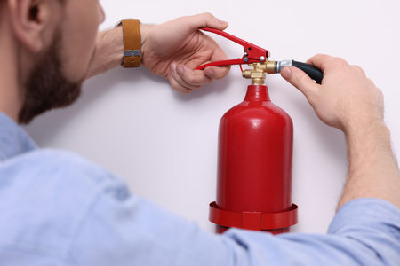 Man checking the quality of fire extinguisher indoors, closeupの写真素材