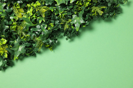 Green artificial plants on color background, top view. Space for textの写真素材
