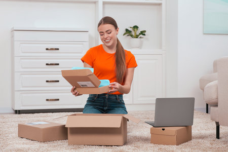 Happy woman unpacking parcel at home. Online store