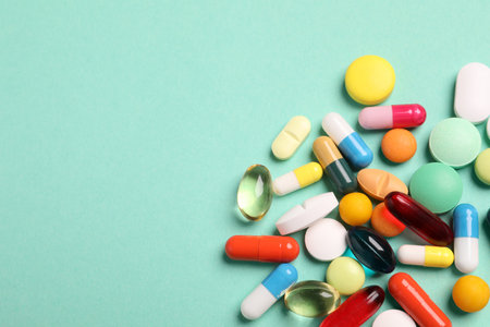 Many different pills on turquoise background, flat lay. Space for textの写真素材