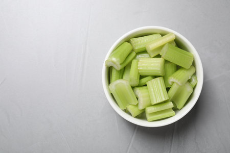 Fresh green cut celery on light gray table, top view. Space for textの写真素材