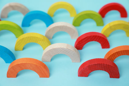 Colorful wooden pieces of playing set on light blue background. Educational toy for motor skills developmentの写真素材