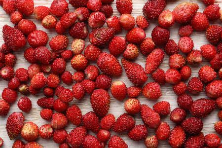 Many fresh wild strawberries on white wooden table, flat layの写真素材