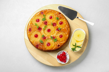 Tasty pineapple cake and ingredients on white textured table, top viewの写真素材