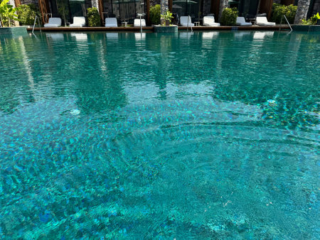 Swimming pool, exotic plants, umbrellas and sunbeds at luxury resortの写真素材