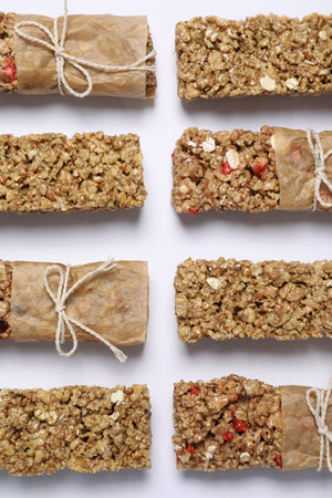 Different tasty granola bars on white background, flat layの写真素材