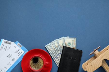 Flat lay composition with passport, dollars and tickets on blue table, space for text. Business tripの写真素材