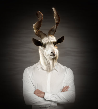Portrait of businessman with goat face on dark backgroundの写真素材
