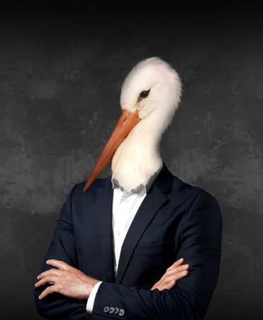 Portrait of businessman with stork face on dark backgroundの写真素材