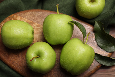 Ripe green apples with leaves and water drops on wooden table, flat layの写真素材