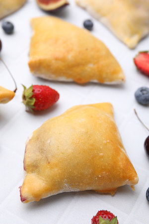 Delicious samosas and berries on white tiled table, closeupの写真素材