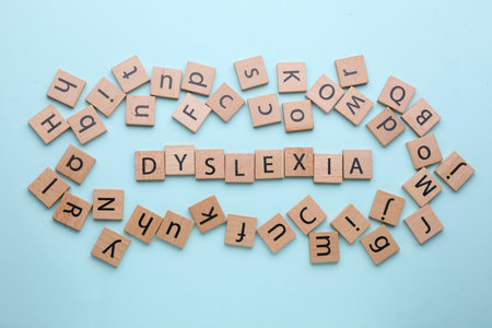 Wooden tiles with the word Dyslexia on light blue background, flat layの写真素材