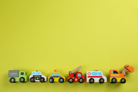 Different toy cars for children on yellow background, flat lay. Space for textの写真素材