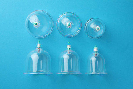 Plastic cups on light blue background, flat lay. Cupping therapyの写真素材