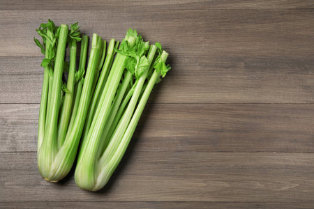 Fresh green celery stalks on wooden table, flat lay. Space for textの写真素材
