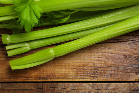Fresh green celery bunches on wooden table, top view. Space for textの写真素材