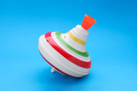 One bright spinning top on light blue background. Toy whirligigの写真素材