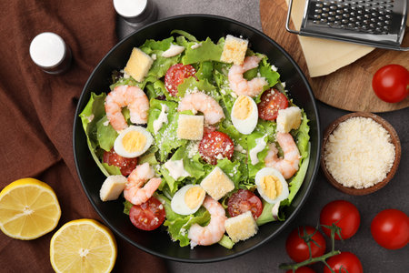Delicious Caesar salad with shrimps and ingredients on brown table, flat layの写真素材