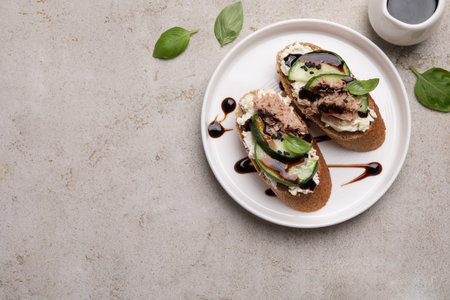 Delicious bruschettas with balsamic vinegar and toppings on light textured table, flat lay. Space for textの写真素材