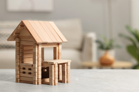 Wooden house on light gray table indoors, closeup. Space for text. Children's toysの写真素材