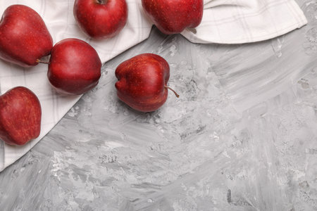 Fresh red apples on gray textured table, flat lay. Space for textの写真素材
