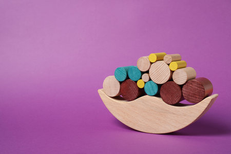 Wooden balance toy on purple background, space for text. Children's developmentの写真素材