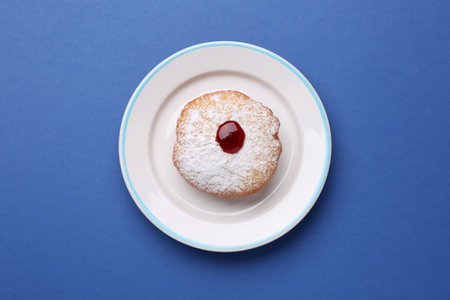 Hanukkah donut with jelly and powdered sugar on blue background, top viewの写真素材