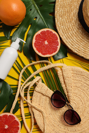 Flat lay composition with beach bag and green leaves on orange backgroundの写真素材