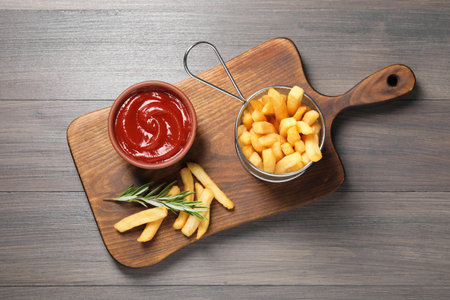 Delicious French fries served with ketchup on wooden table, top viewの写真素材