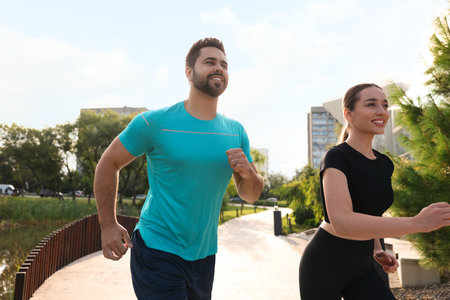 Healthy lifestyle. Happy couple running outdoors on sunny day