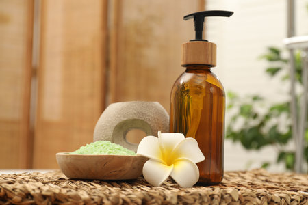 Different spa products and beautiful flower on wicker table, closeupの写真素材