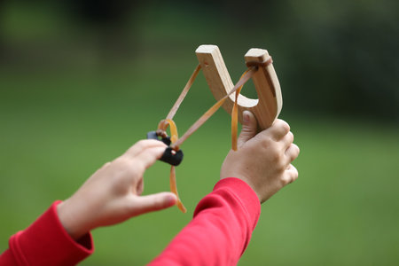 Little boy playing with slingshot outdoors, closeupの写真素材