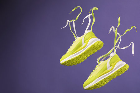 Pair of stylish sneakers on purple background. Space for textの写真素材