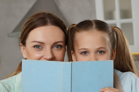 Woman and her daughter with recipe book in kitchen, closeupの写真素材